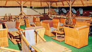 An indoor space with multiple seating areas, including chairs and tables, under a thatched roof structure. - Mirton Hotel (Bujumbura)