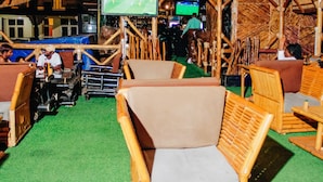 A rustic-themed bar area with wooden furniture and a green carpet. - Mirton Hotel (Bujumbura)