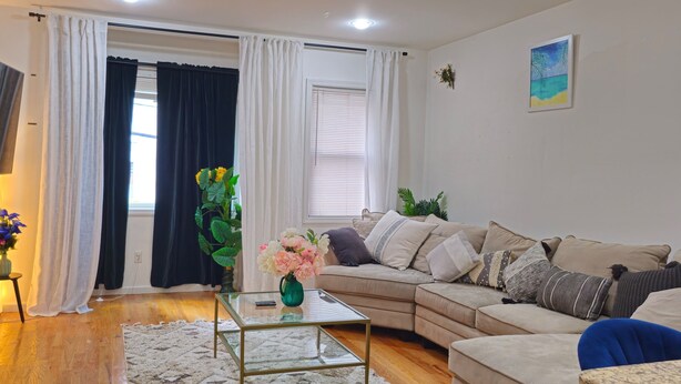 Una sala de estar con un sofá, una mesa de centro y un televisor montado en la pared.