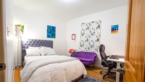 Un dormitorio con una cama, un escritorio y una silla.