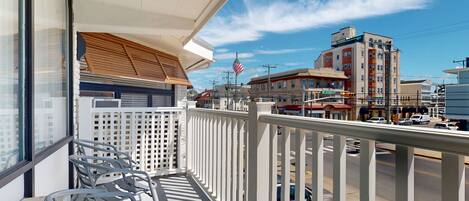 Parveke, josta avautuu näkymä kadulle, ja näkyvissä on myös lippu ja rakennuksia.