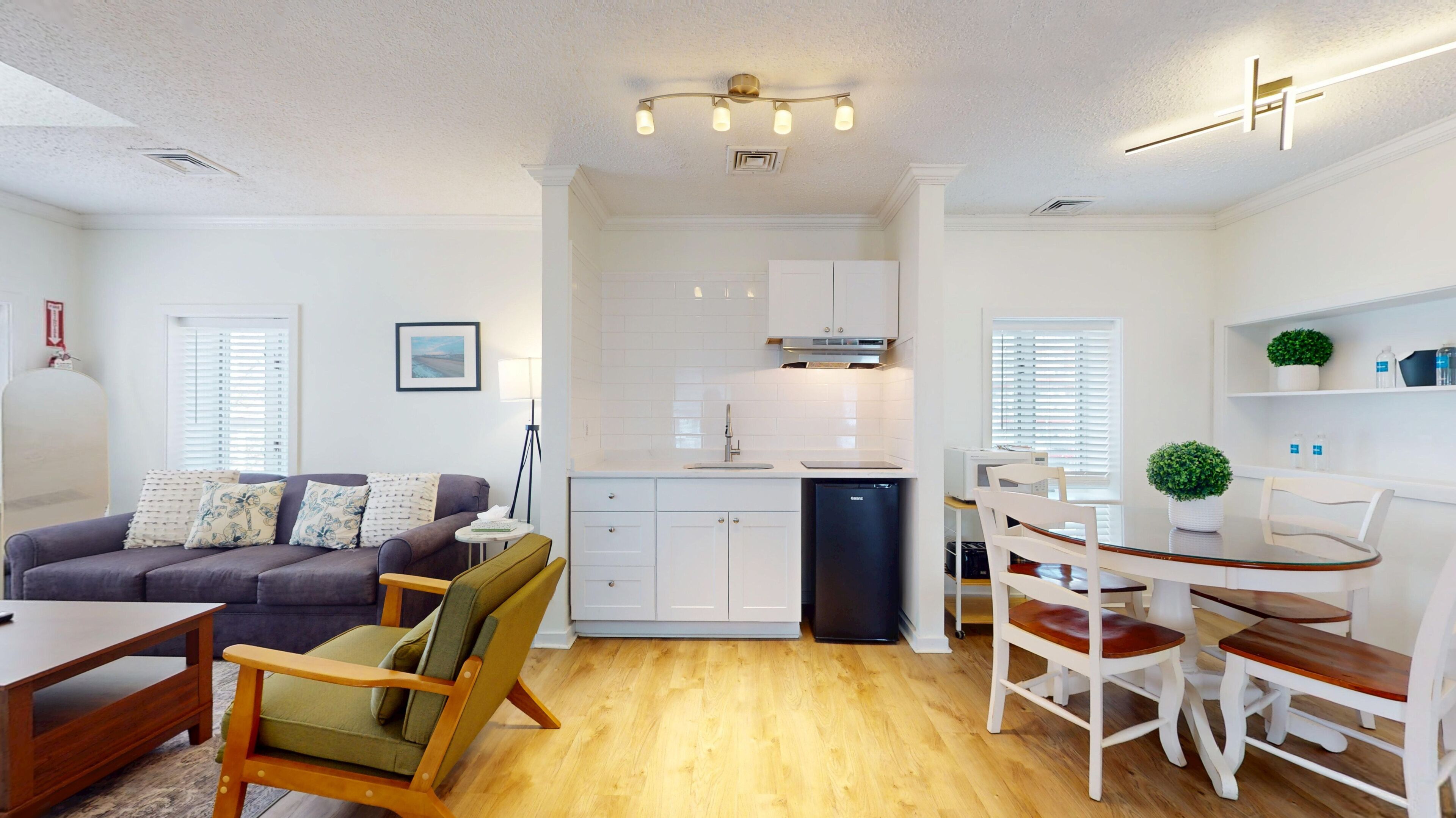 Un appartement moderne comprenant un salon, une cuisine, un coin repas et un petit balcon.