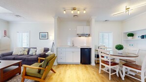 A modern apartment with a living room, kitchen, dining area, and a small balcony. - Queen Suite Upper (502) (Ocean City)