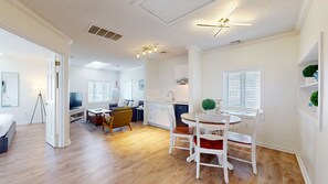A modern apartment with a living room, dining area, kitchen, and a balcony.