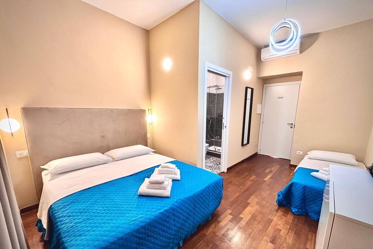 Habitación de hotel con una cama grande, ducha y un escritorio pequeño.