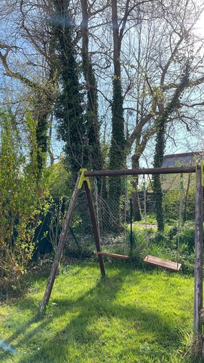 Relax in a serene garden setting with a charming wooden swing.