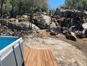 A wooden deck with a pool, surrounded by large rocks and trees. - Luxury villa with a large garden near Porto-Vecchio   (Porto-Vecchio)