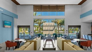 A spacious lobby with a pool view, comfortable seating, and a modern design.