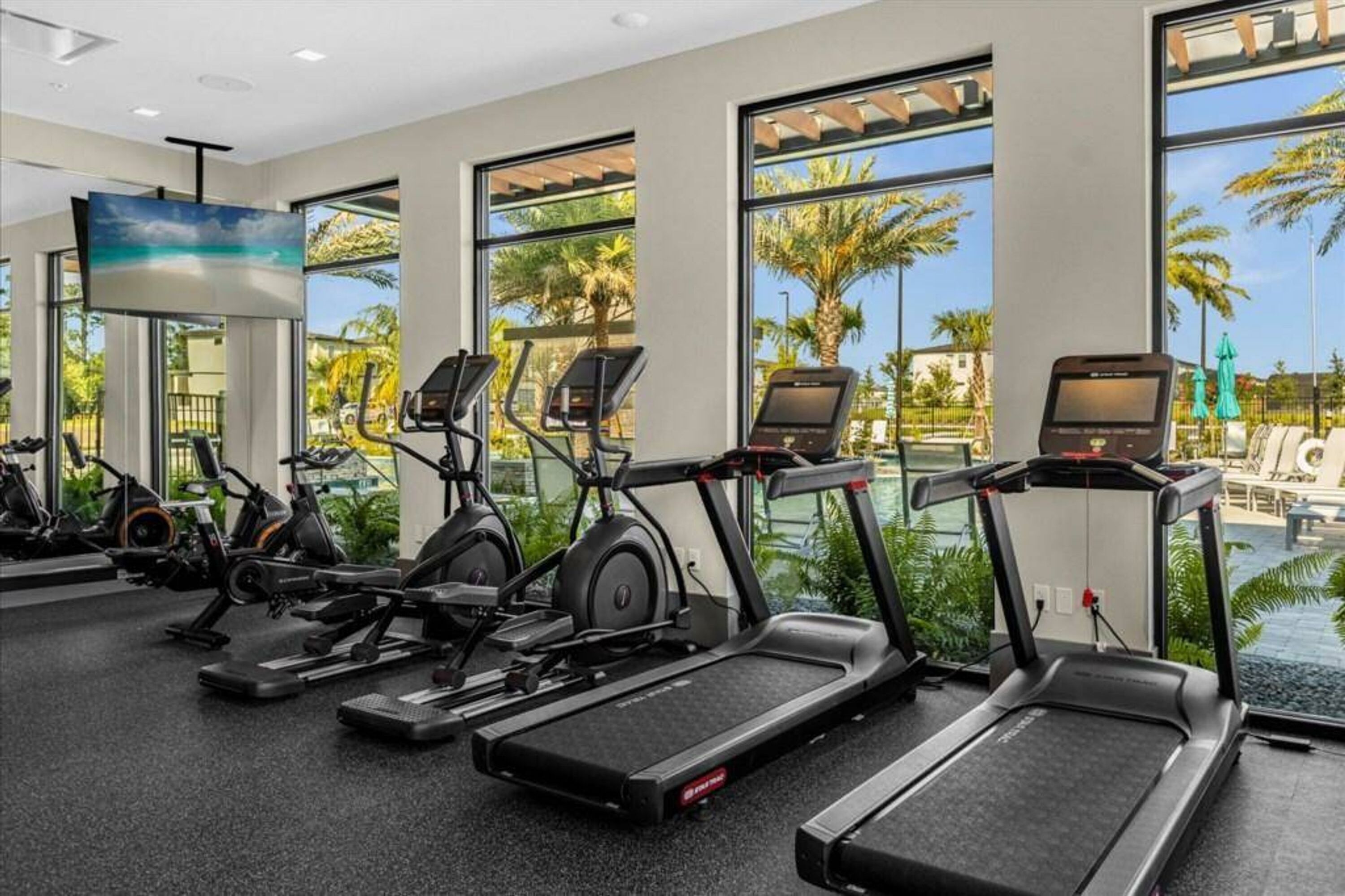 A gym with treadmills, stationary bikes, and elliptical machines.