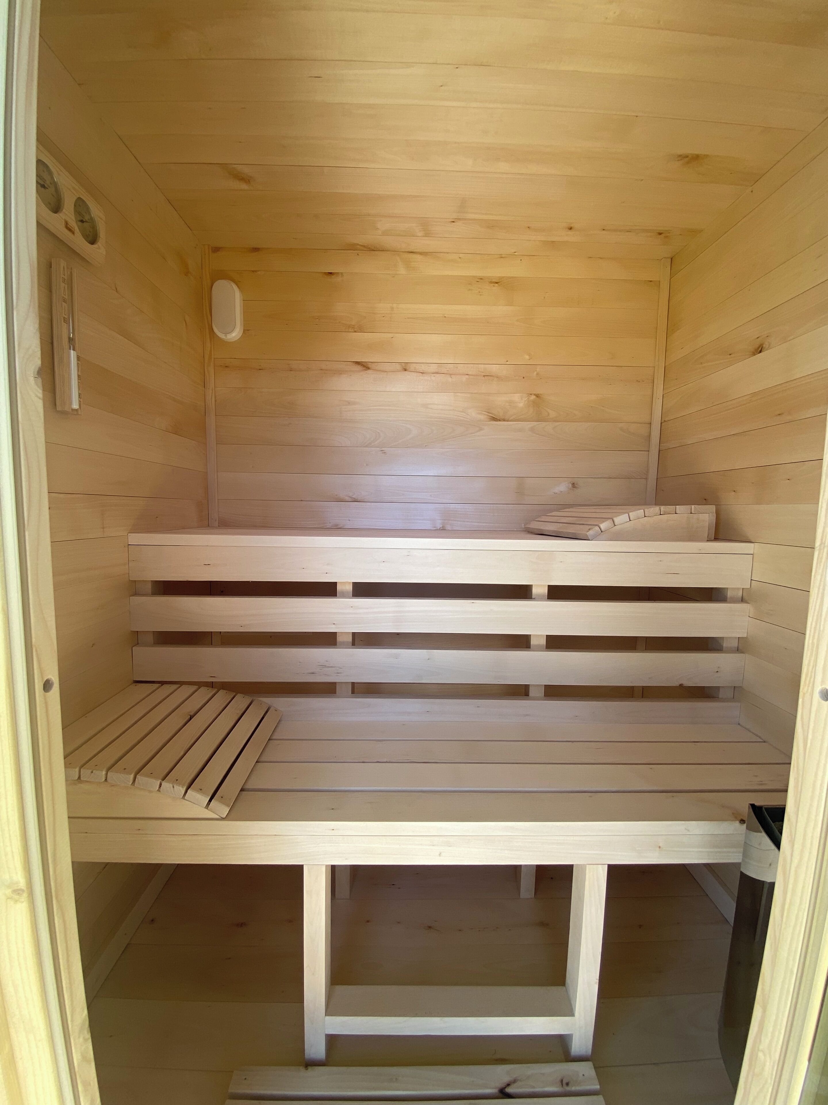 A wooden sauna with benches and a bench seat.