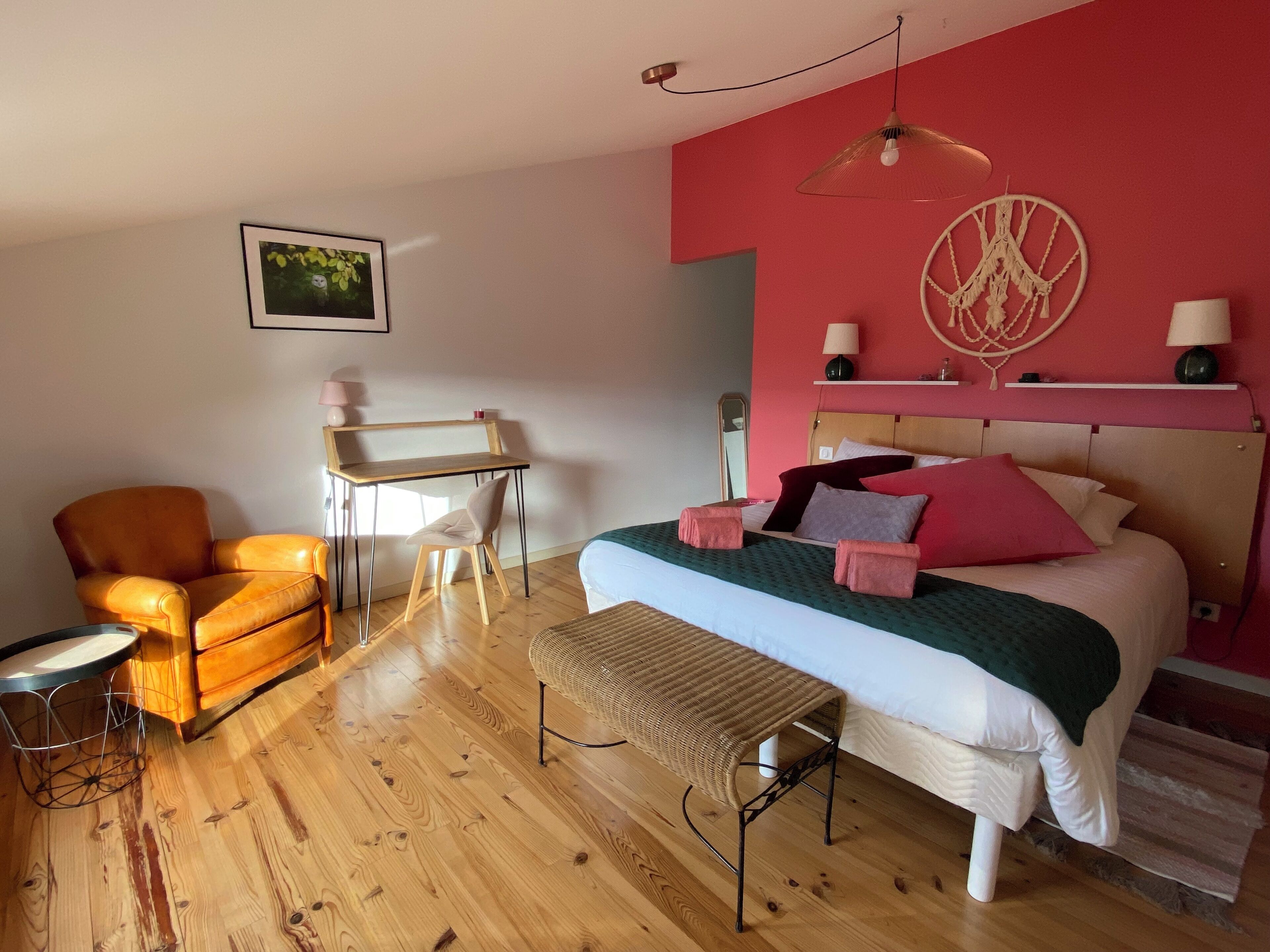 A bedroom with a bed, a desk, a chair, and a bench.