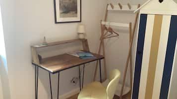 Une pièce comprenant un bureau, une chaise et un meuble rayé.