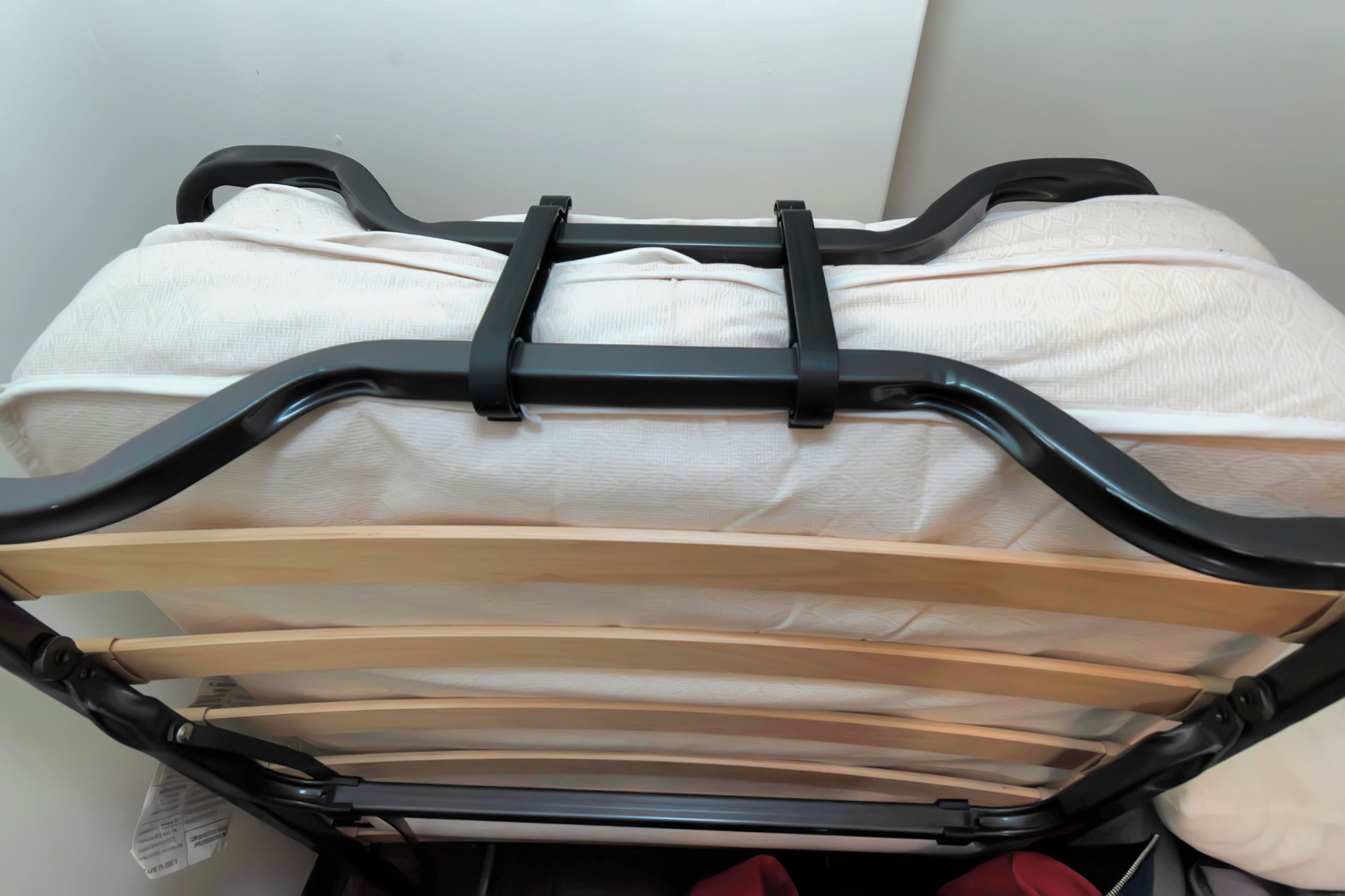 A bed with a black metal frame and white bedding.