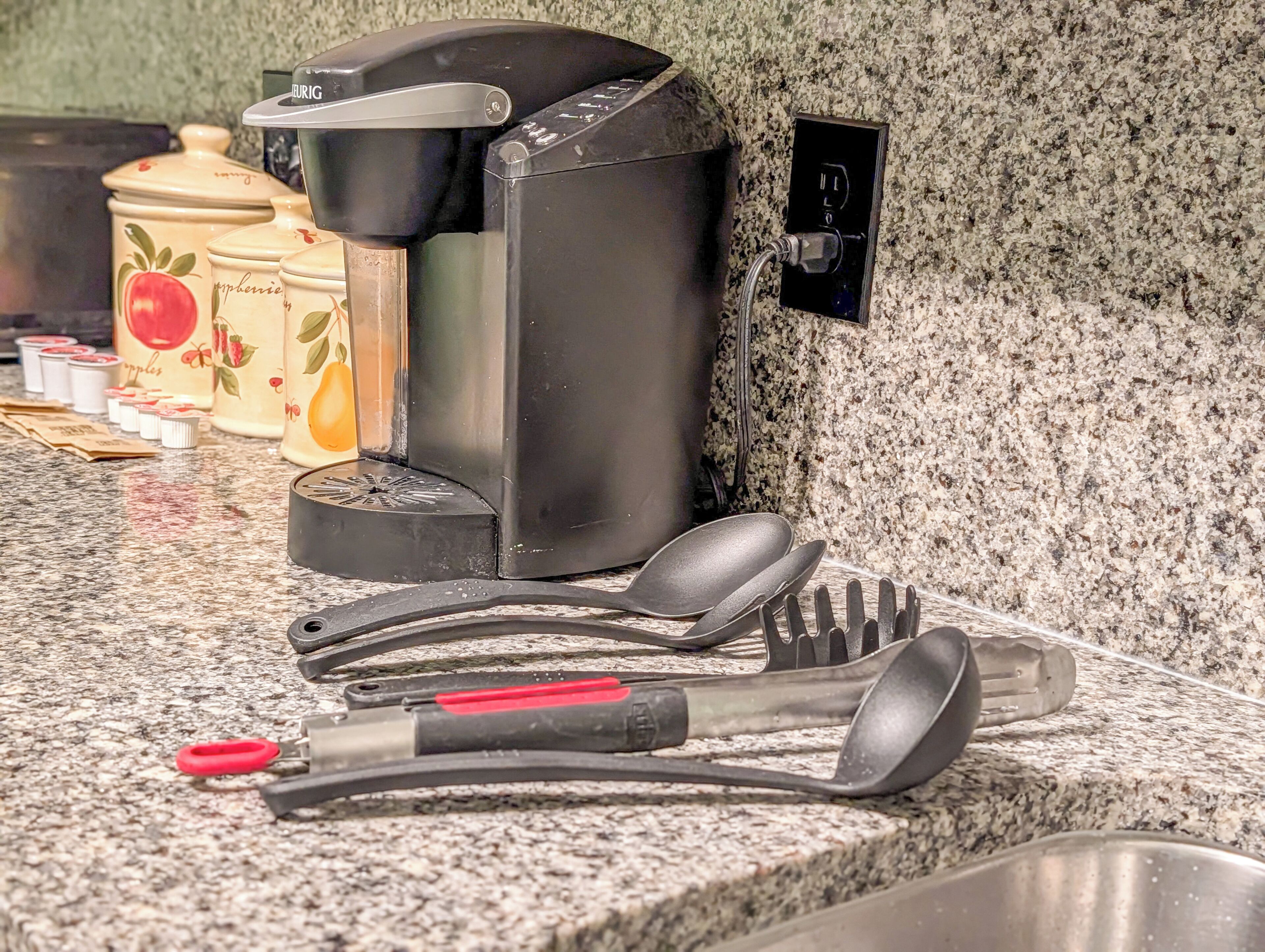 Eine Küchenarbeitsplatte mit Kaffeemaschine, Geschirr und dekorativen Behältern.