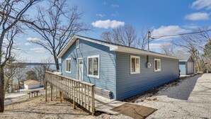 A single-story house with a front porch and a small deck, surrounded by trees and a gravel driveway. - 3 Mi to the Lake: Rocky Mount Home w/ Water Views! (Rocky Mount)