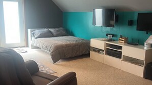 Una camera da letto con un letto, una TV, una scrivania e una sedia.