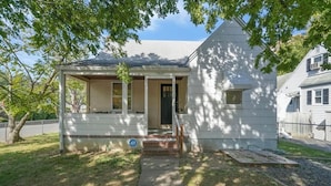 A small, single-story house with a porch, a front door, and a mailbox.
