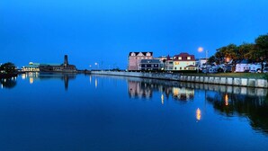 Un passeig marítim tranquil amb edificis reflectits a l'aigua.
