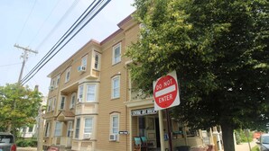 Un bâtiment à deux étages avec une pancarte « Entrée interdite », un porche avec une chaise et une pancarte indiquant « Maison de Central Avenue ».