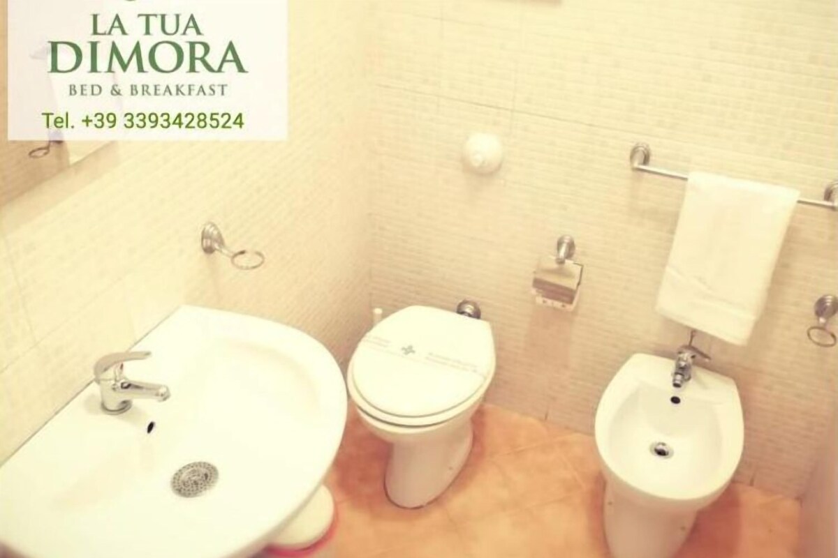 A small bathroom with a sink, toilet, and bidet.