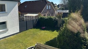A residential area with houses, a grassy yard, and a wooden fence.