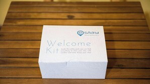 Een welkomstpakket in een doos op een houten tafel.