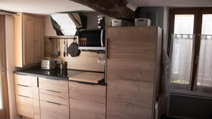 Een keuken met houten kastjes, een magnetron en een broodrooster.