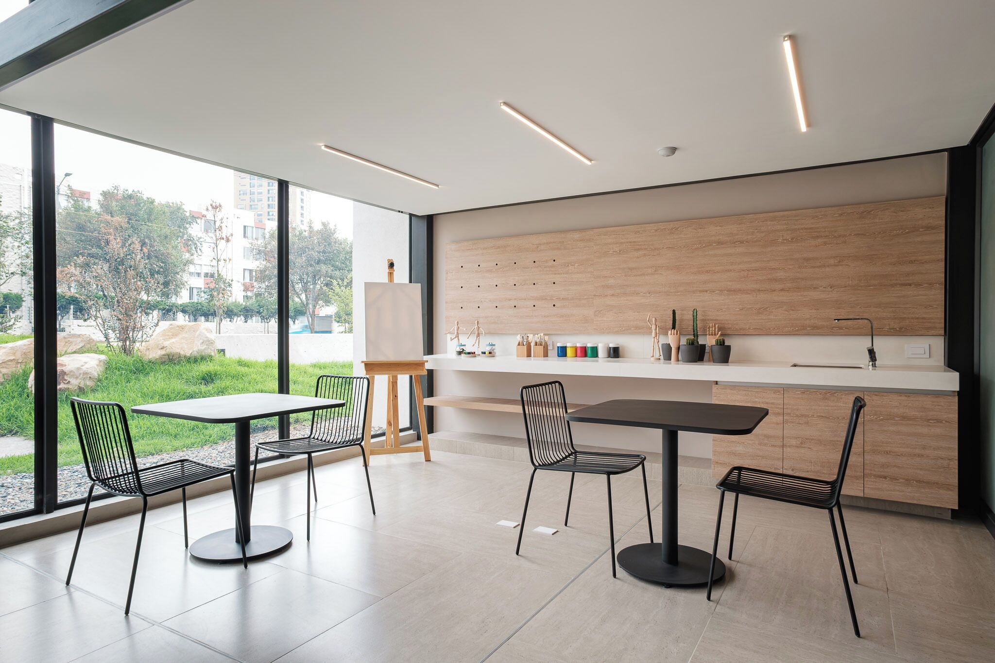 Una cocina moderna con un ventanal grande, un protector contra salpicaduras de madera y una zona de comedor con sillas y una mesa.