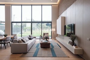 A modern living room with a sofa, coffee table, and TV. - Avanzza by Wellcome (Bogotá)