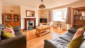 A living room with a fireplace, a television, a coffee table, and leather sofas.