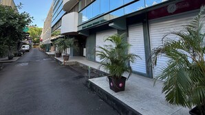 Un bâtiment moderne doté de grandes fenêtres et abritant un commerce au rez-de-chaussée.