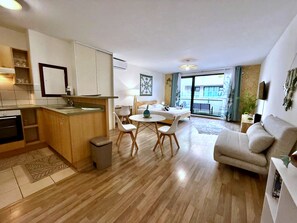Un appartement moderne comprenant une cuisine, un coin repas et un salon.