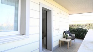 A room with a window, a door, a small table with a potted plant, and a chair. - CV001 – Cervia, comfortable studio apartment on the ground floor (Cervia)
