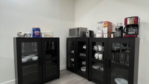 A modern kitchen with black cabinets, a microwave, toaster, and coffee maker. - Cozy & Modern 3BR Lower Unit I Private Entrance, Laundry, Fridge Microwave (Calgary)