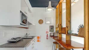 Een moderne keuken met witte tegels, een houten aanrechtblad en een inbouwoven.