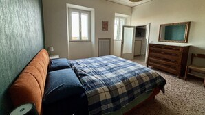 Ein Schlafzimmer mit Bett, Kommode und Fenster.