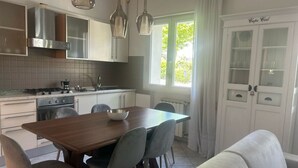 Una cucina moderna con tavolo, sedie e forno a incasso.