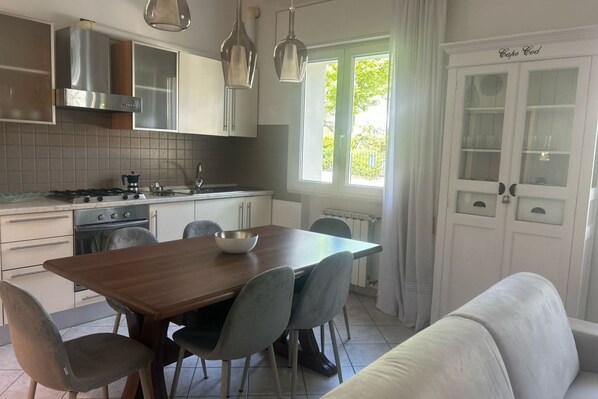 A modern kitchen with a dining table, chairs, and a built-in oven.