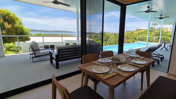 Un comedor con vistas a una piscina y un paisaje pintoresco.