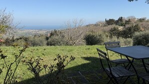 Une terrasse avec une table et des chaises donnant sur un paysage pittoresque.