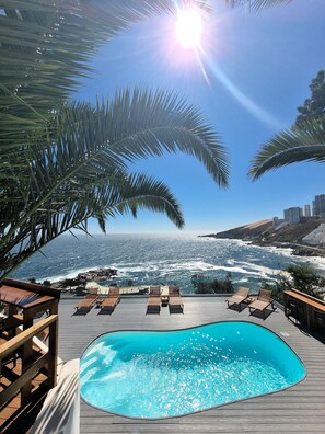 Una piscina con vistas al océano y palmeras.