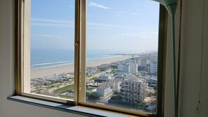 A window with a view of a beach and buildings. - CV011 - Milano Marittima, sea front three-room apartment with exclusive view (Cervia)