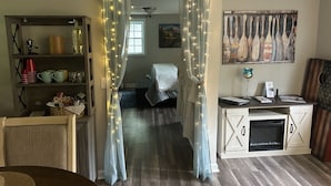A cozy living room with a wooden floor, a dining table, a kitchen area with a stove, and a hallway leading to a bedroom. - Vacation Rental, Spa & Salt Room
Table Rock State Park
Fire-Pit ,Pet Friendly (Pickens)