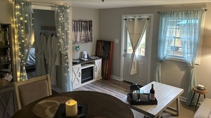A cozy living room with a fireplace, a dining table with candles, and a view of the outdoors through a window with sheer curtains. - Vacation Rental, Spa & Salt Room
Table Rock State Park
Fire-Pit ,Pet Friendly (Pickens)
