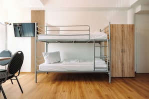 A bunk bed room with a desk, chair, and a TV mounted on the wall. - WzW Apartments - Wohnraum zum Wohlfühlen (Neubrandenburg)