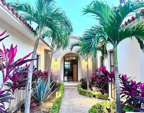 A courtyard with a stone pathway, palm trees, and various plants. - Casa Flip Flop - New, Luxury 4-bedroom (Cabo San Lucas)