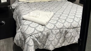 A bedroom with a bed, a bedside table, a nightstand, a window, and a door. - Charming RV in Lovely Oxford with AC, WiFi (Oxford)