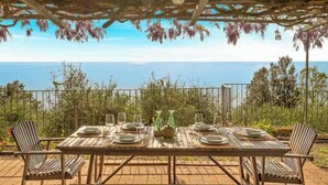 An outdoor dining area with a table set for four, overlooking a scenic view of the sea. - Villa Mesco 360, Terre Marine (Levanto)