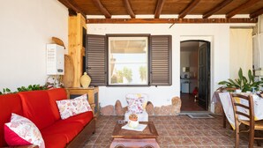 A cozy living area with a red sofa, a wooden coffee table, and a dining table with chairs.