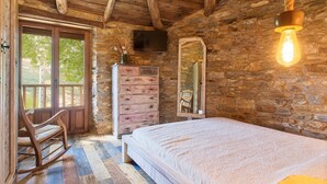 Una habitación rústica de madera con cama, cómoda y mecedora.